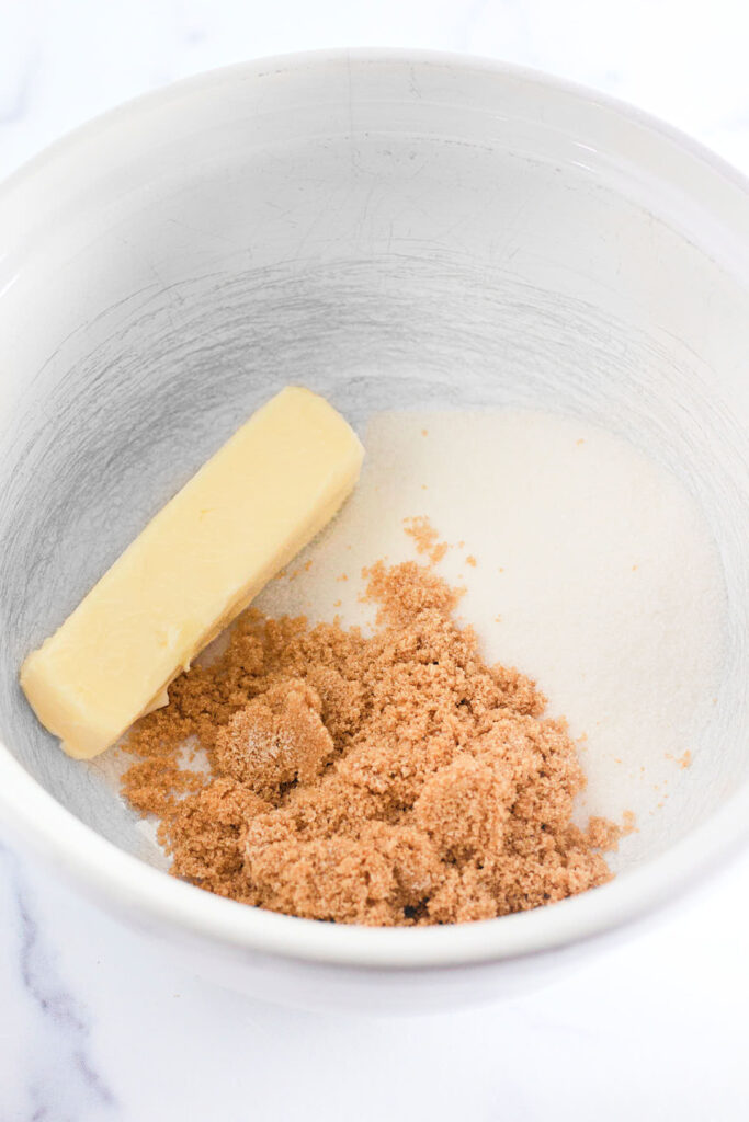 Sugar and butter in a bowl to be combined.